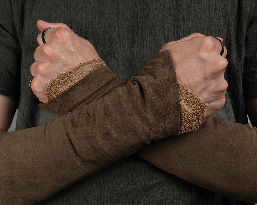 Brown suede bracers layered with beige armbands, close-up – ZOLNAR