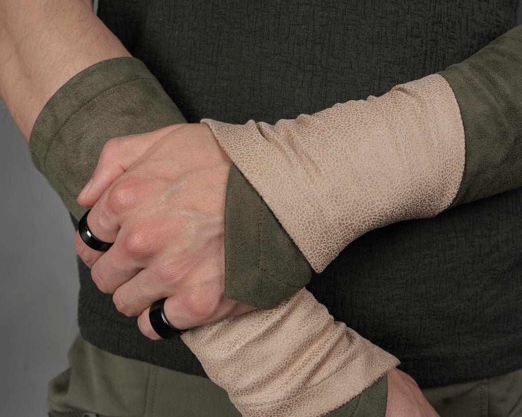 Khaki suede bracers layered with beige faux leather armbands on crossed arms – ZOLNAR