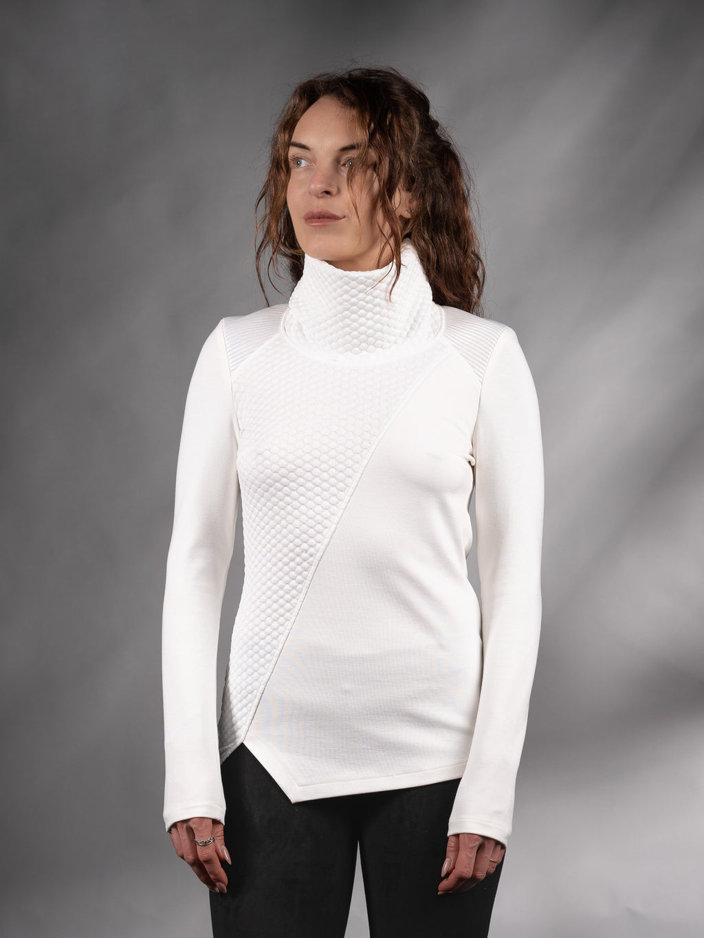 Front view of white asymmetrical sweater with high collar and angled hem, solarpunk – ZOLNAR