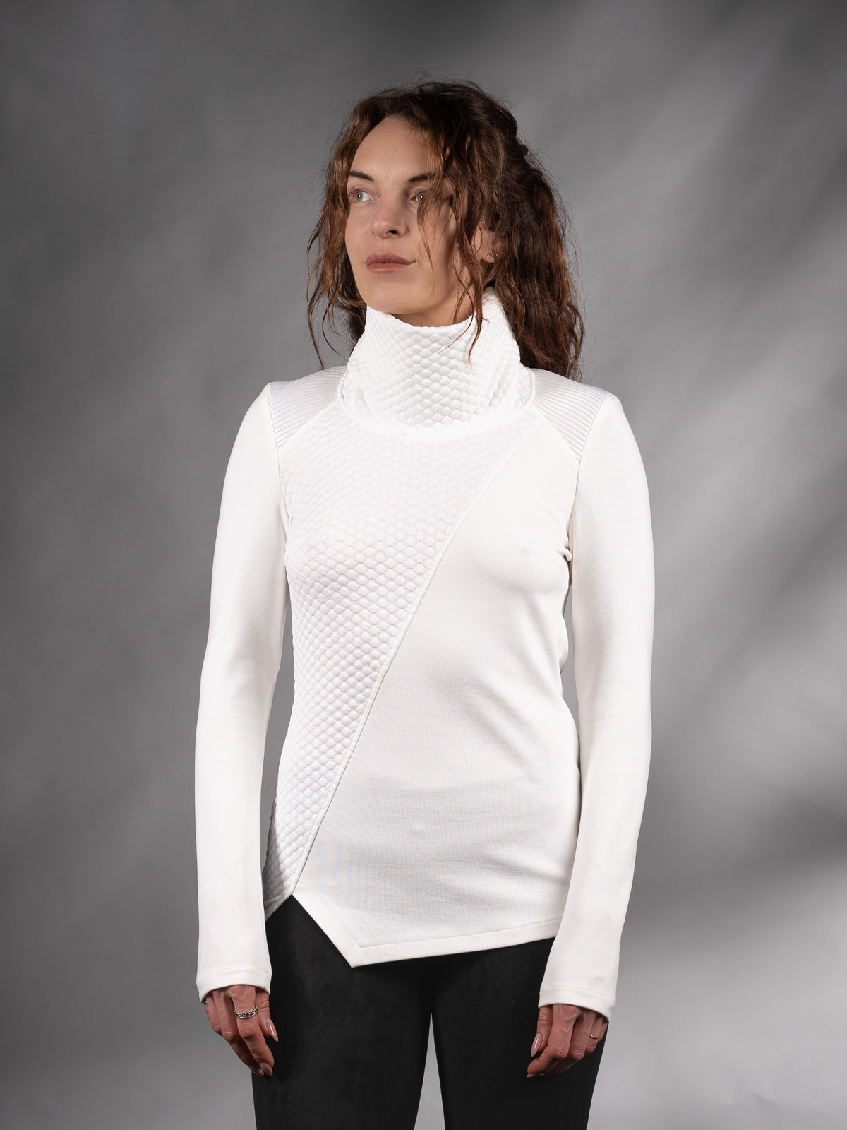 Front view of white asymmetrical sweater with high collar and angled hem, solarpunk – ZOLNAR