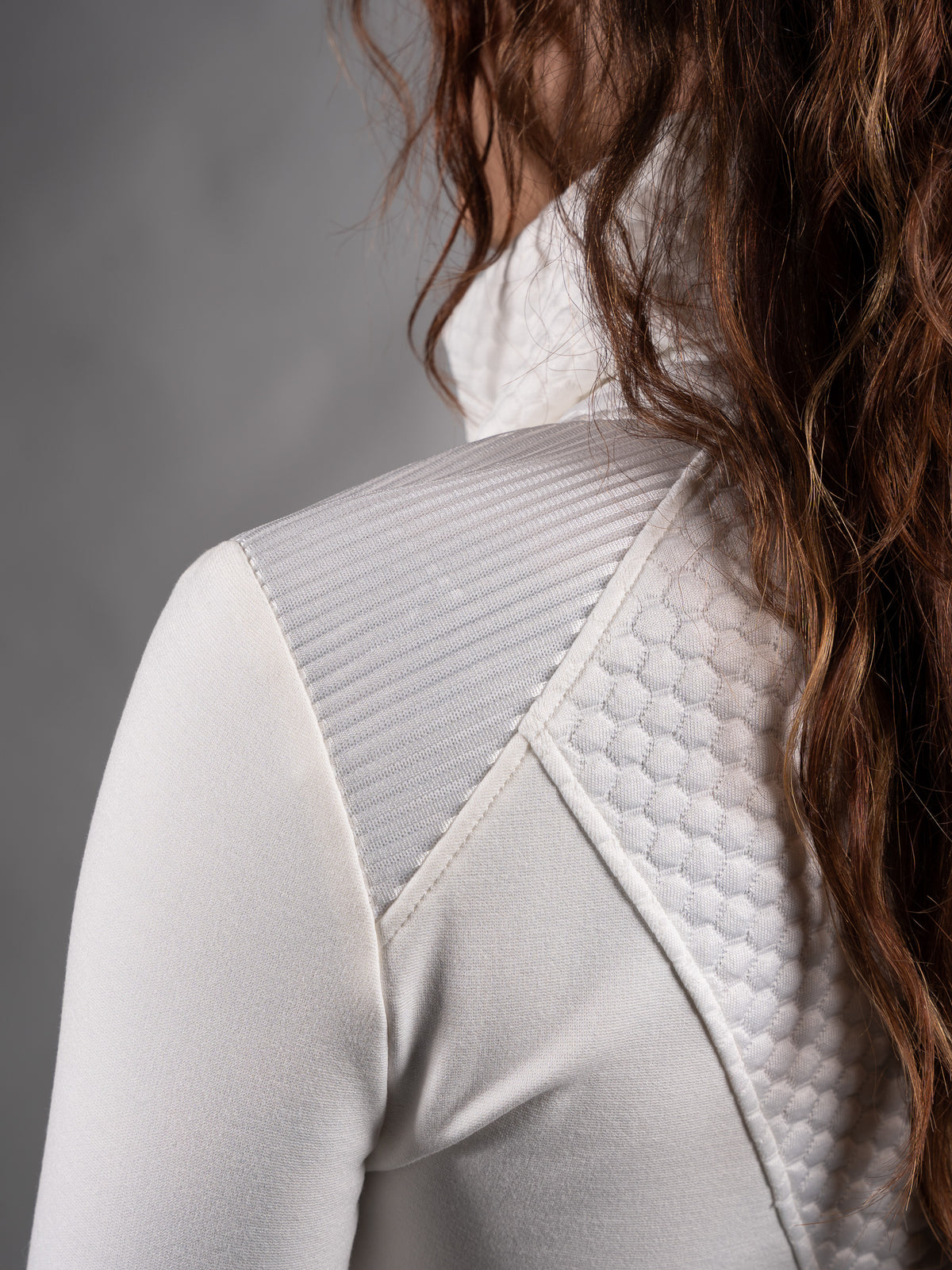 Close-up of quilted textured jersey panel on the shoulder of white sweater – ZOLNAR