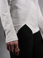Close-up of asymmetric hem and textured panel on white sweater – ZOLNAR