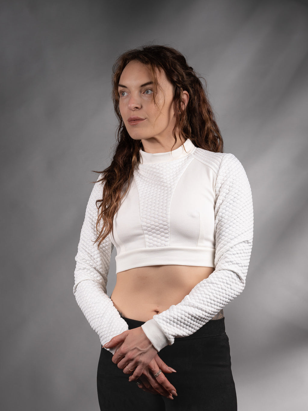 Front view of white long-sleeve crop top with black trousers, solarpunk style – ZOLNAR