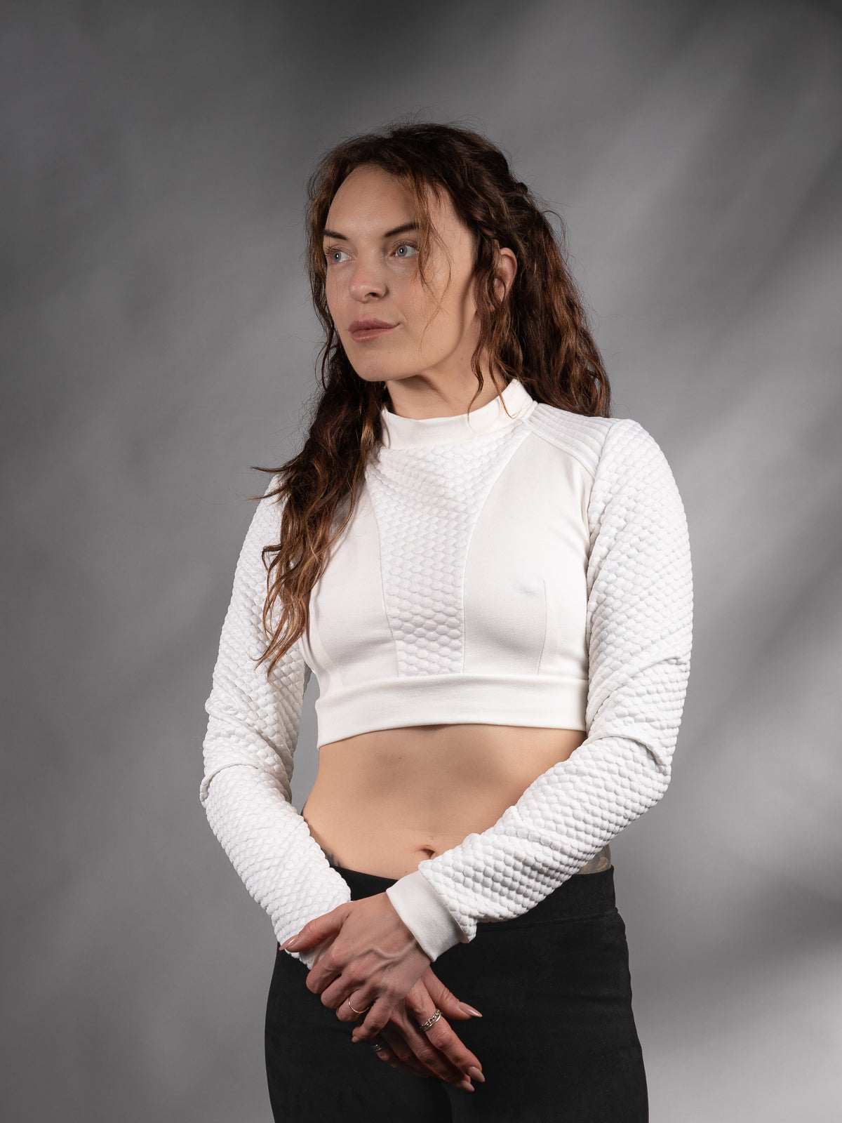 Front view of white long-sleeve crop top with black trousers, solarpunk style – ZOLNAR