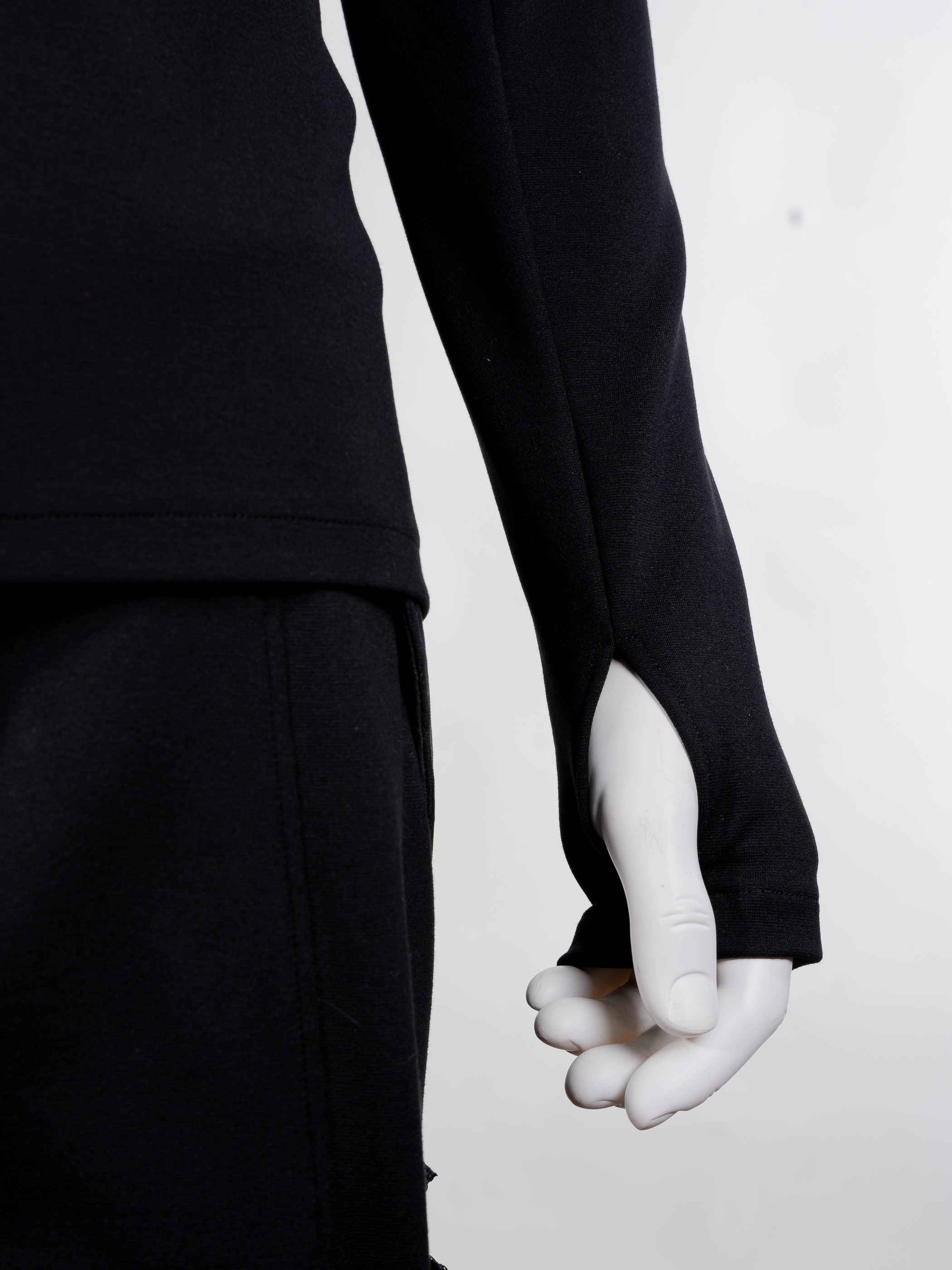 Person wearing a black long-sleeve top and pants on a white background